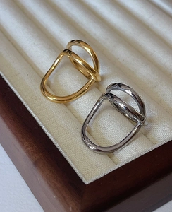 Detailed view of irregular twisted gold and silver rings in a beige velvet jewelry box
