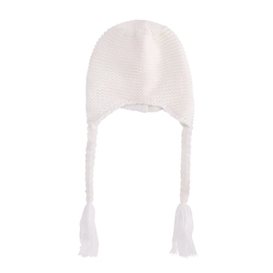 Detailed knit texture of white baby winter hat with long braided tassels and earflaps