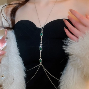 Close-up of emerald crystal chest chain with rhinestone tassels on silver body jewelry
