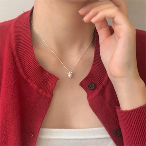Elegant 925 silver necklace featuring a white pearl and bow pendant on a model