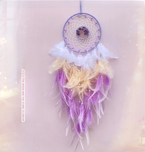 Detailed view of handmade dream catcher with purple crystal tree of life and soft feathers