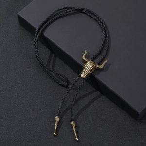 Vintage western bolo tie with bronze bull skull pendant and black braided leather cord