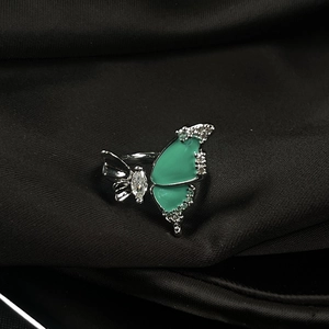Detail of silver butterfly ring with turquoise enamel wings and crystal inlay on black silk