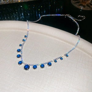 Macro detail of silver geometric necklace with blue zircon stones and sparkling star effect