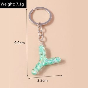 Detailed view of resin letter Y keychain with green sequins and silver metal ring