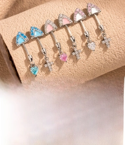 Macro view of titanium steel cartilage studs with heart and cross zircon pendants