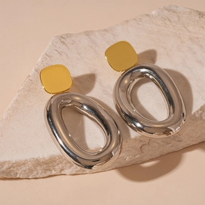 Elegant two-tone geometric oval earrings with gold square studs on a natural stone base