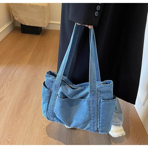 Detail of a large denim tote bag with multiple pockets in a casual Japanese style