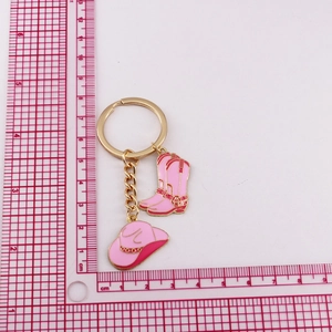Detailed measurement of pink enamel cowboy hat and boot charms on a metal keychain