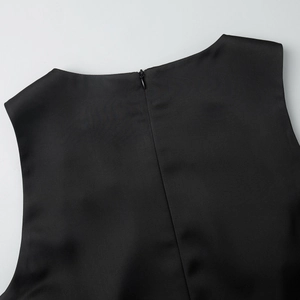 Detail of a sleek black satin dress showing the invisible back zipper and smooth texture