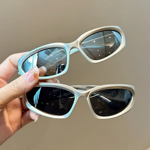 Détail de lunettes de soleil de sport Y2K argentées avec verres gris foncé et monture