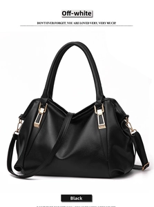Detail of black lychee grain leather tote bag featuring gold hardware and removable strap