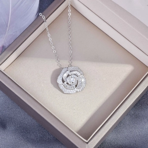 Macro detail of silver camellia necklace with pavé cubic zirconia in a jewelry box
