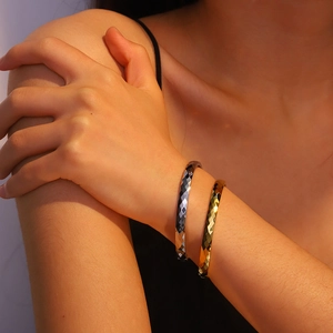 Detail shot of gold and silver titanium steel bangles with faceted geometric cutting