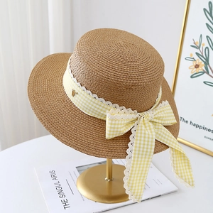 Handwoven boater straw hat with yellow gingham ribbon and lace trim on a gold stand