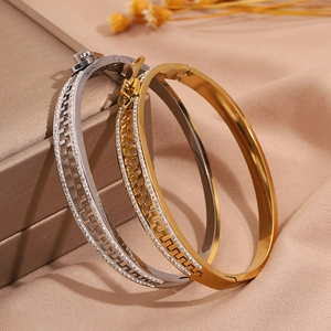 Detail of silver and gold Greek key open bangles with sparkling zircon inlay