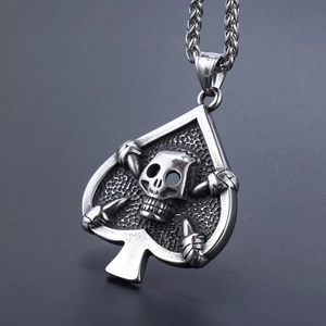Macro shot of vintage silver skull pendant with Ace of Spades frame and punk texture