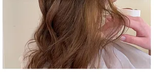 Delicate cherry hair claw clip accenting long dark brown wavy hair in a side view