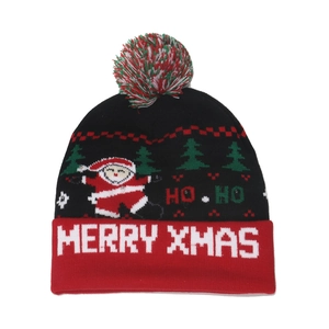 Detail of knit Christmas hat featuring Santa Claus, Merry Xmas text and a colorful pompom