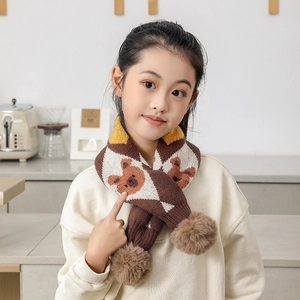 Détail d'une écharpe tricotée pour enfants avec motif ours et pompons en peluche