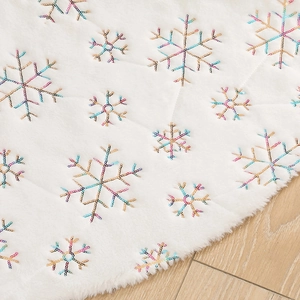 White plush Christmas tree skirt with colorful sequin snowflake embroidery decorations