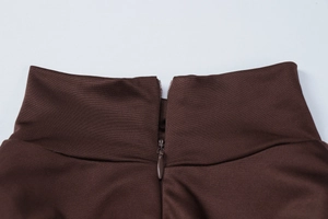 Dettaglio della cerniera invisibile e della trama in maglia sull'abito marrone