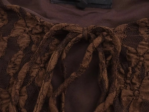 Detail of dark brown lace and knit fabric featuring a stylish lace-up tie design