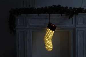Close-up of a large white knit Christmas stocking with glowing LED lights and red cuff