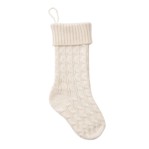 Detail of cream white cable knit Christmas stocking with hanging loop and textured wool