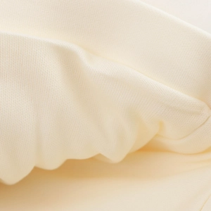 Vista macro dettagliata della trama del tessuto a maglia crema con morbide increspature