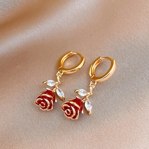 Boucles d'oreilles fleurs dorées avec roses rouges et zircons sur fond de soie chic