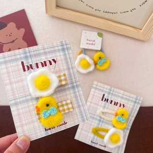 Detail of handmade fabric hair ties and clips with cute egg and chicken patterns