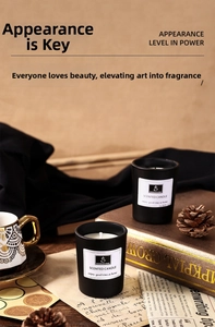 Close-up of black ceramic scented candles with white labels in a cozy home setting
