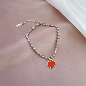 Detail of silver stainless steel beaded bracelet with red heart enamel pendant