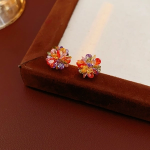 Detailed view of cluster flower earrings with multicolored crystals in a velvet box