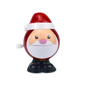 Close-up of a plastic wind-up Santa Claus toy with a white knob on a white background