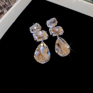 Macro shot of silver drop earrings featuring faceted clear crystals on black velvet