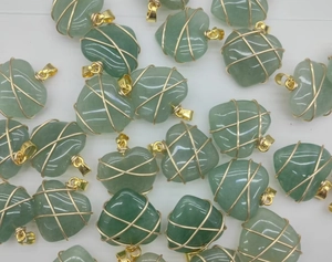 Detailed view of handmade green heart pendants with gold wire wrapping craftmanship