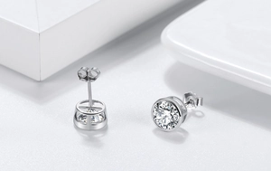 Close-up of S925 sterling silver stud earrings featuring bezel-set round white cubic zirconia