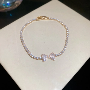 Detailed macro shot of bow pendant gold bracelet with sparkly zircons and pavé rhinestones