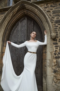 Detailed view of a gold metallic mirror belt on a white off-the-shoulder evening gown
