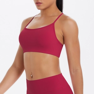Détail de l'ensemble de yoga bordeaux avec fines bretelles croisées et legging taille haute