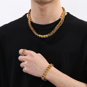 Close-up of golden bicycle chain style jewelry set including necklace, bracelet, and ring