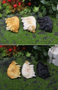 Detaillierte Nahaufnahme von drei Miniatur-Hunden aus Harz, die im Gras schlafen