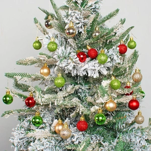 Colorful painted Christmas ball ornaments hanging on a snowy tree in a holiday gift box
