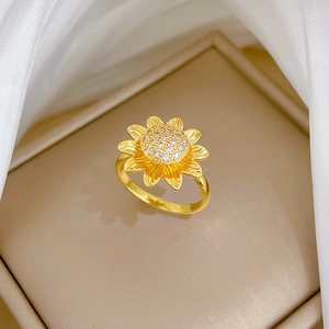 Golden rotating sunflower ring with sparkling zircon inlays on an elegant display base
