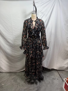 Detail of V-neck ruffled long dress with red floral and white Paisley patterns and belt