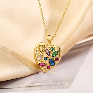 Macro detail of gold hollow heart pendant necklace with multi-colored gemstones on silk