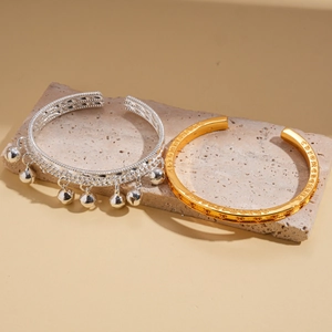 Ensemble de bracelets joncs plaqués or et argent avec breloques sur support pierre