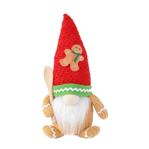 Christmas gnome doll with gingerbread hat and wooden spoon decoration in festive colors